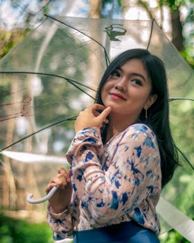 一位时尚女性撑着伞，在郁郁葱葱的户外环境中摆姿势的肖像