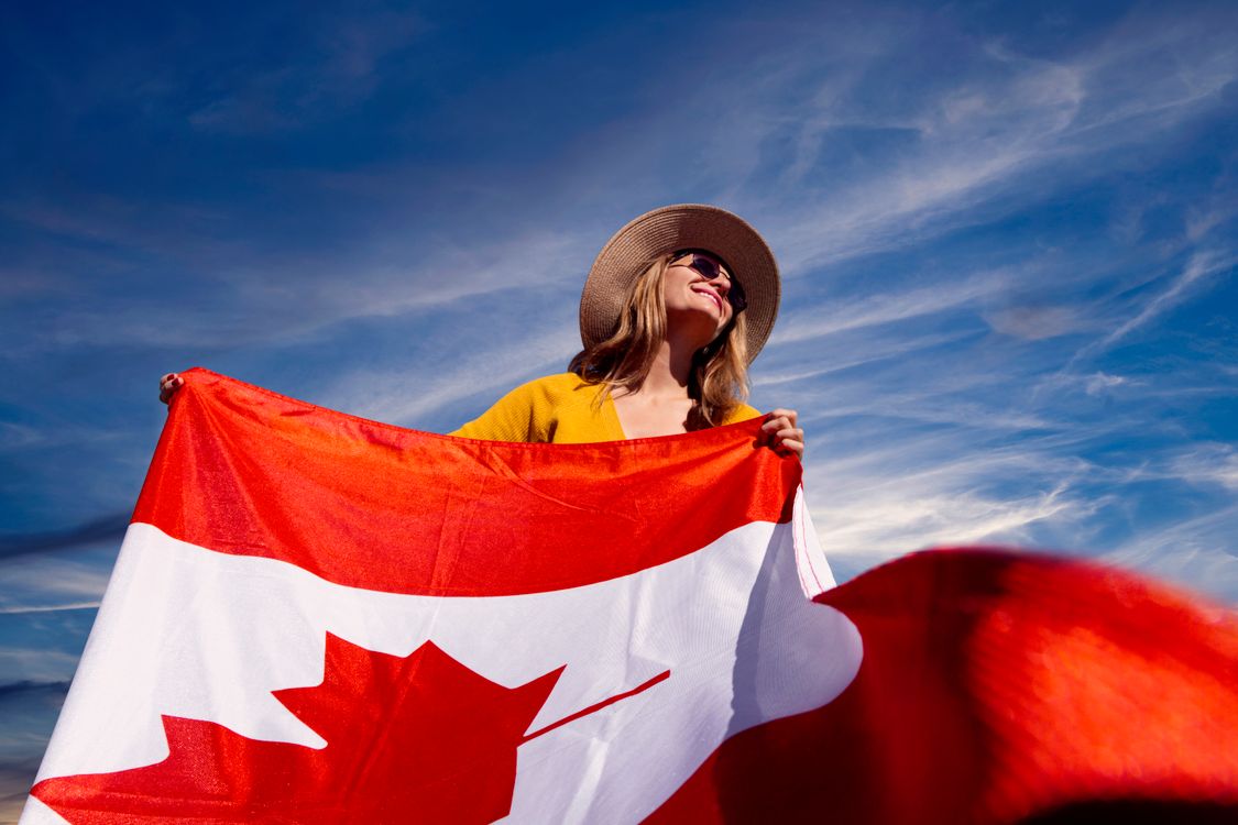 A Photograph of a Woman Holding a Canadian Flag · Free Stock Photo