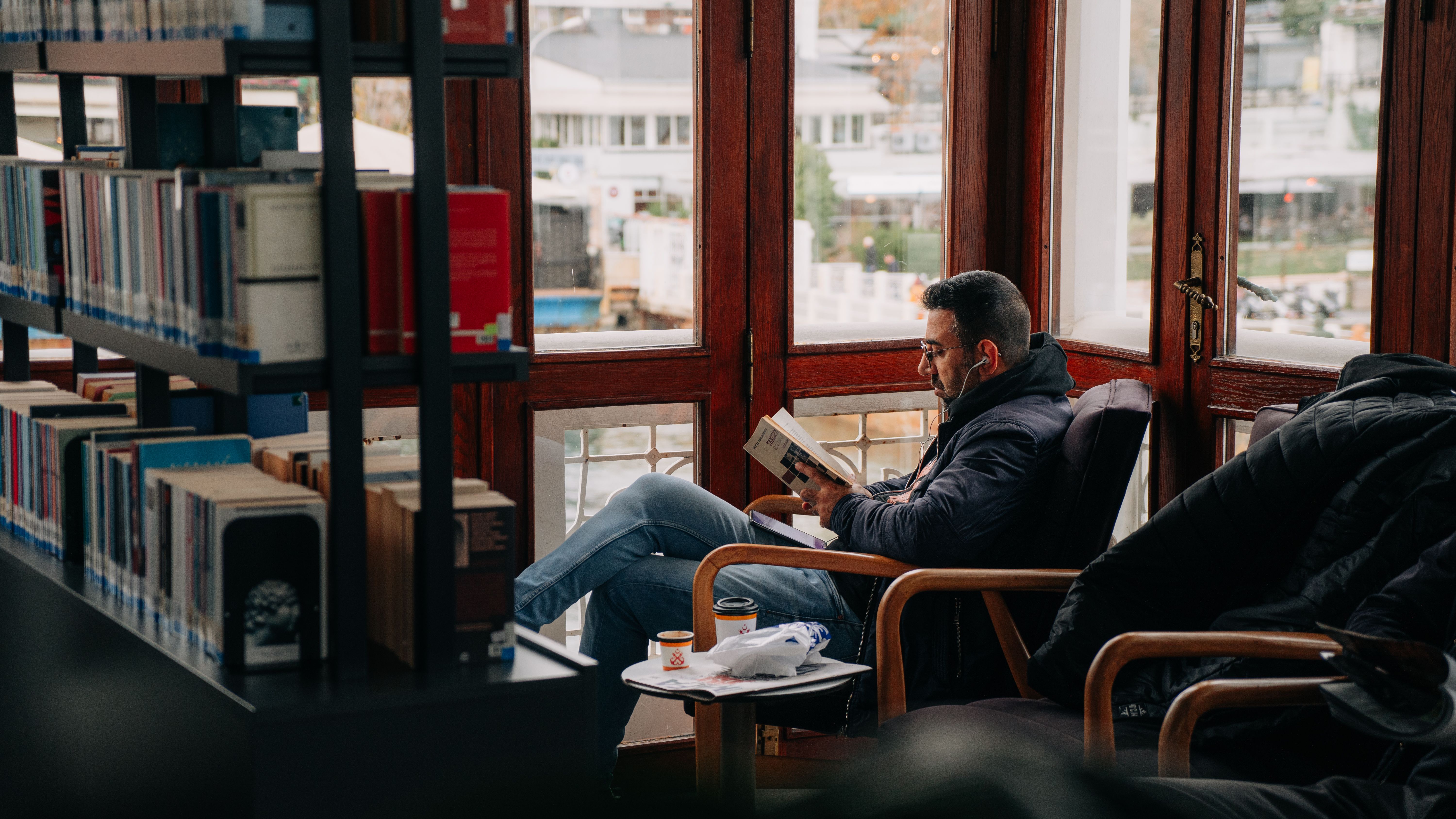 person reading book in cozy library - free activity when broke