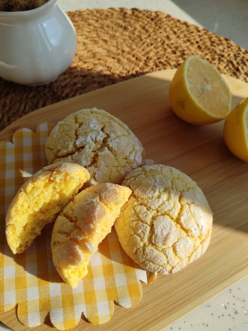 Free Delicious lemon cookies displayed with fresh lemon halves on a sunny wooden board. Stock Photo