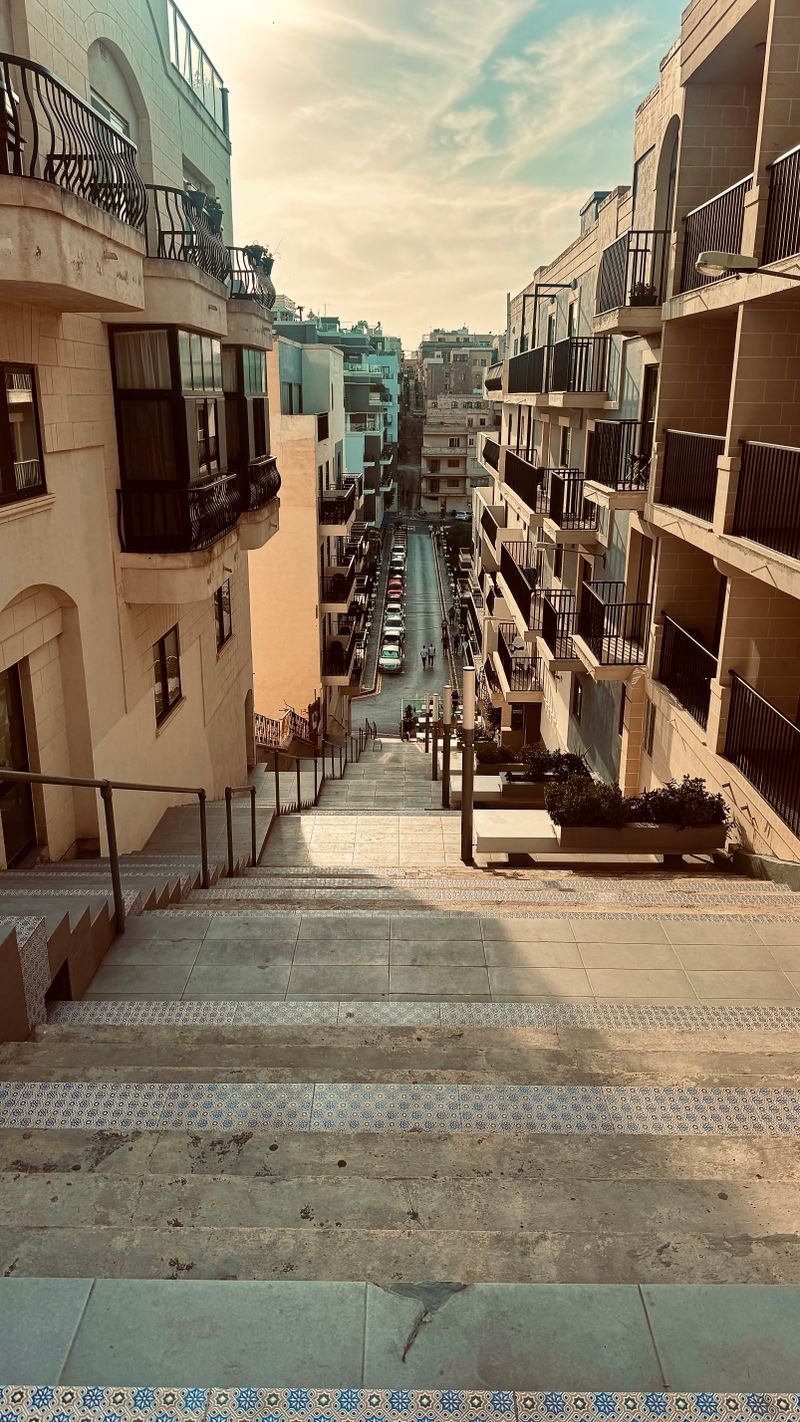 Stone stairway and narrow street in Mellieha, Malta, the kind of access that adds time to a cleaner's visit