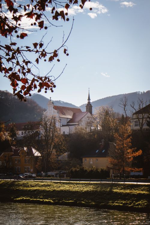 Free A tranquil autumn scene featuring a church in Celje, Slovenia, with a clear blue sky and scenic landscape. Stock Photo