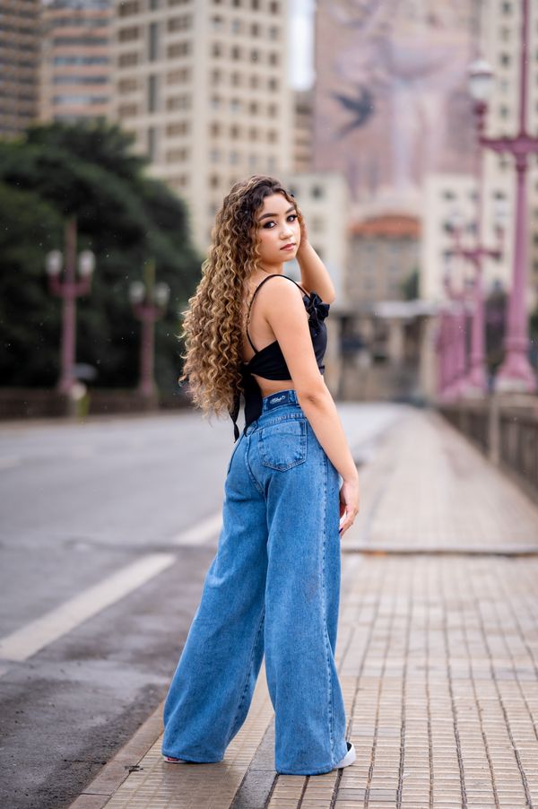 Fashionable woman in jeans on urban bridge