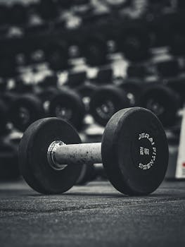 A heavy dumbbell on the floor of a modern gym, ideal for fitness themes.