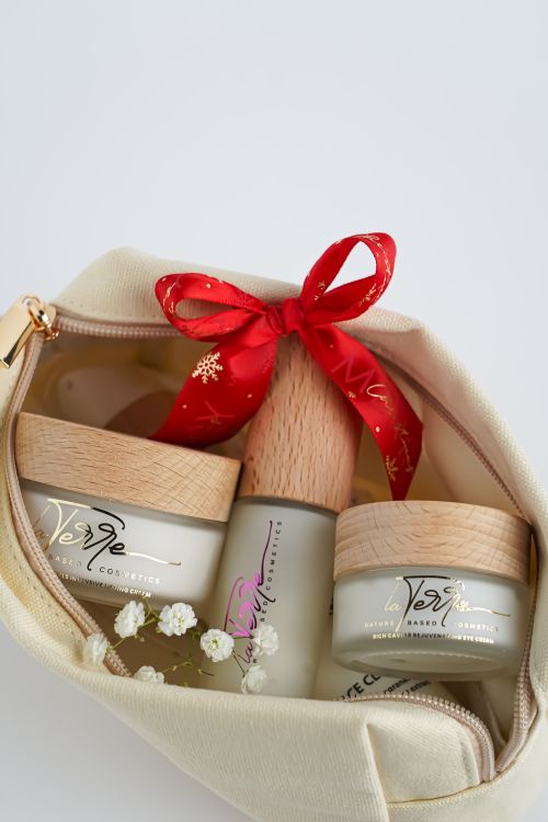 Free Chic cosmetic products in a stylish beige pouch tied with a red ribbon, perfect for gifts. Stock Photo