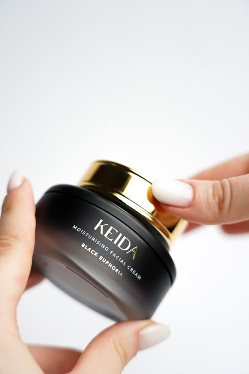 Free Moisturizing facial cream in a sleek black jar with gold lid, perfect for skincare routines. Stock Photo