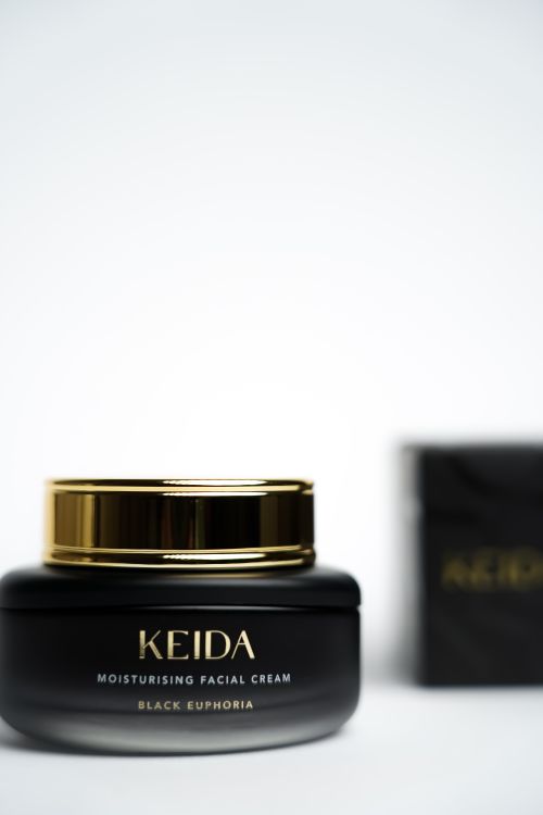 Free Close-up of Keida moisturizing facial cream in an elegant black jar with gold accents. Stock Photo