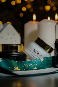 Luxury skincare products with candles and Christmas decor create a festive ambiance.