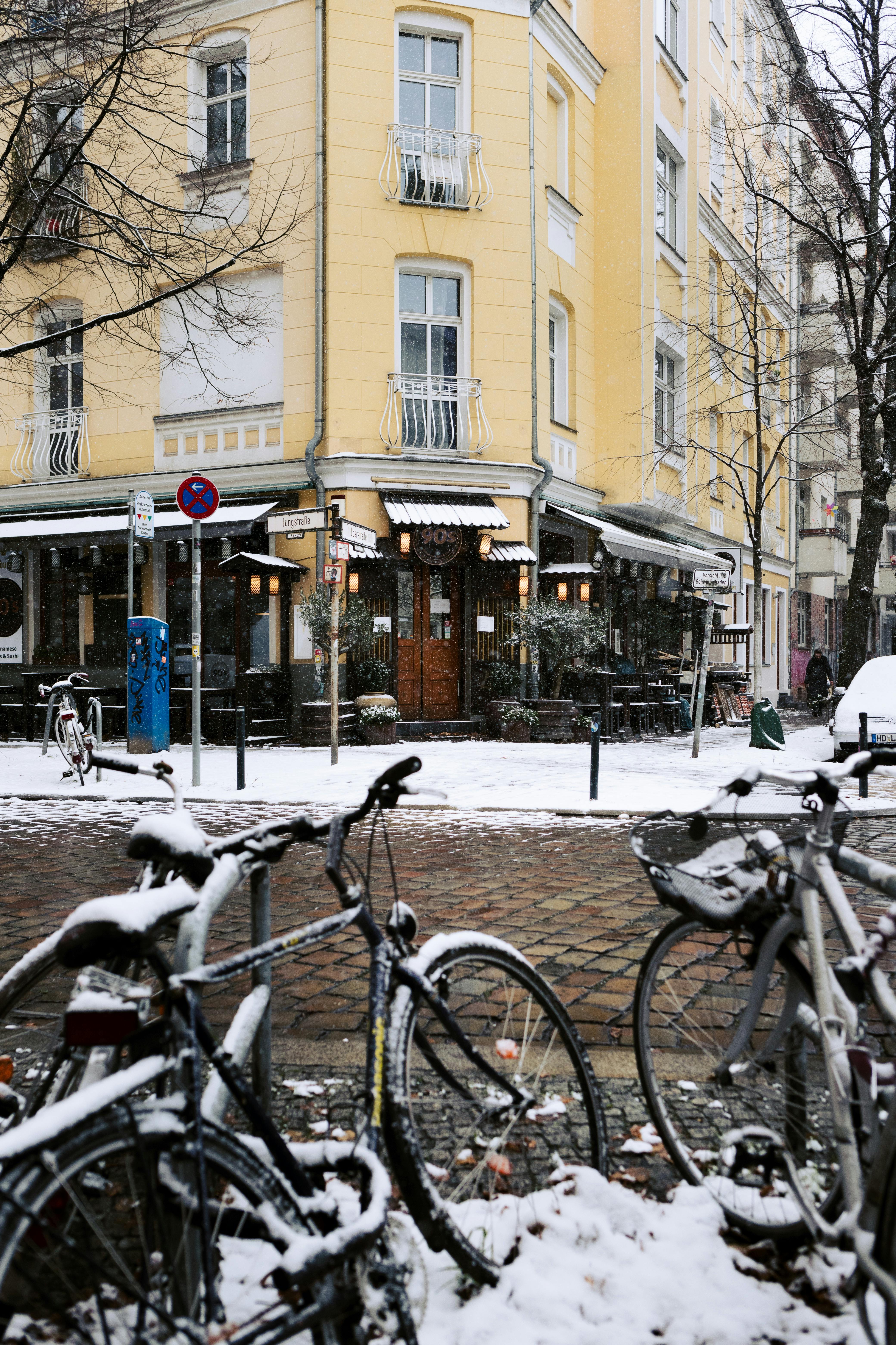 snowy berlin street with yellow apartment building