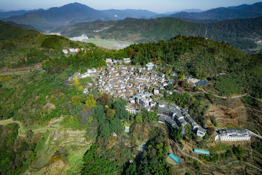 Picturesque aerial view of a traditional Chinese village nestled in lush green mountains.