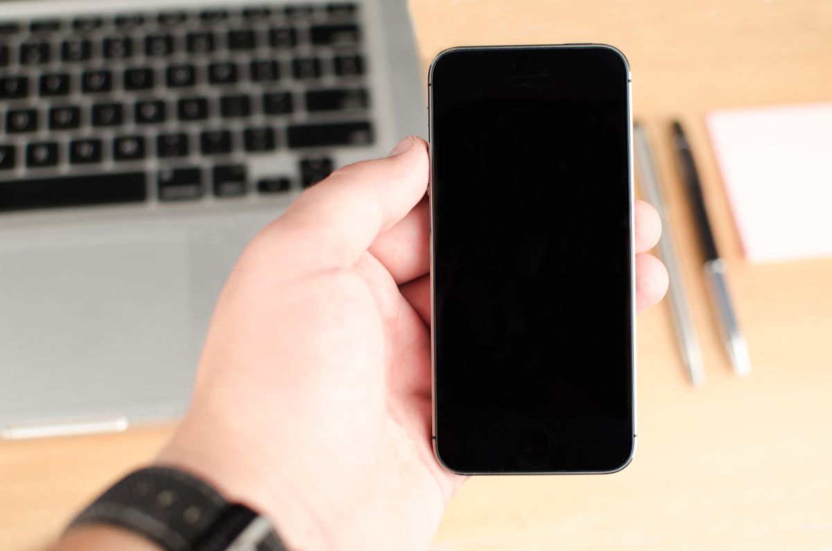 Elinde akıllı telefon tutan bir kişi mobil uygulama kullanıyor