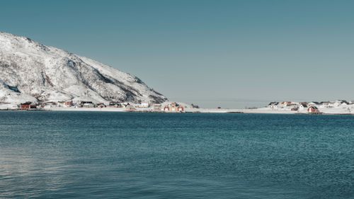 Free Snow-covered Sommarøy against clear skies, reflecting Norwegian charm. Stock Photo