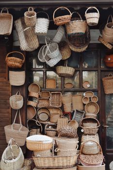 Various wicker baskets hanging and stacked in an outdoor rustic display, showcasing traditional craftsmanship.