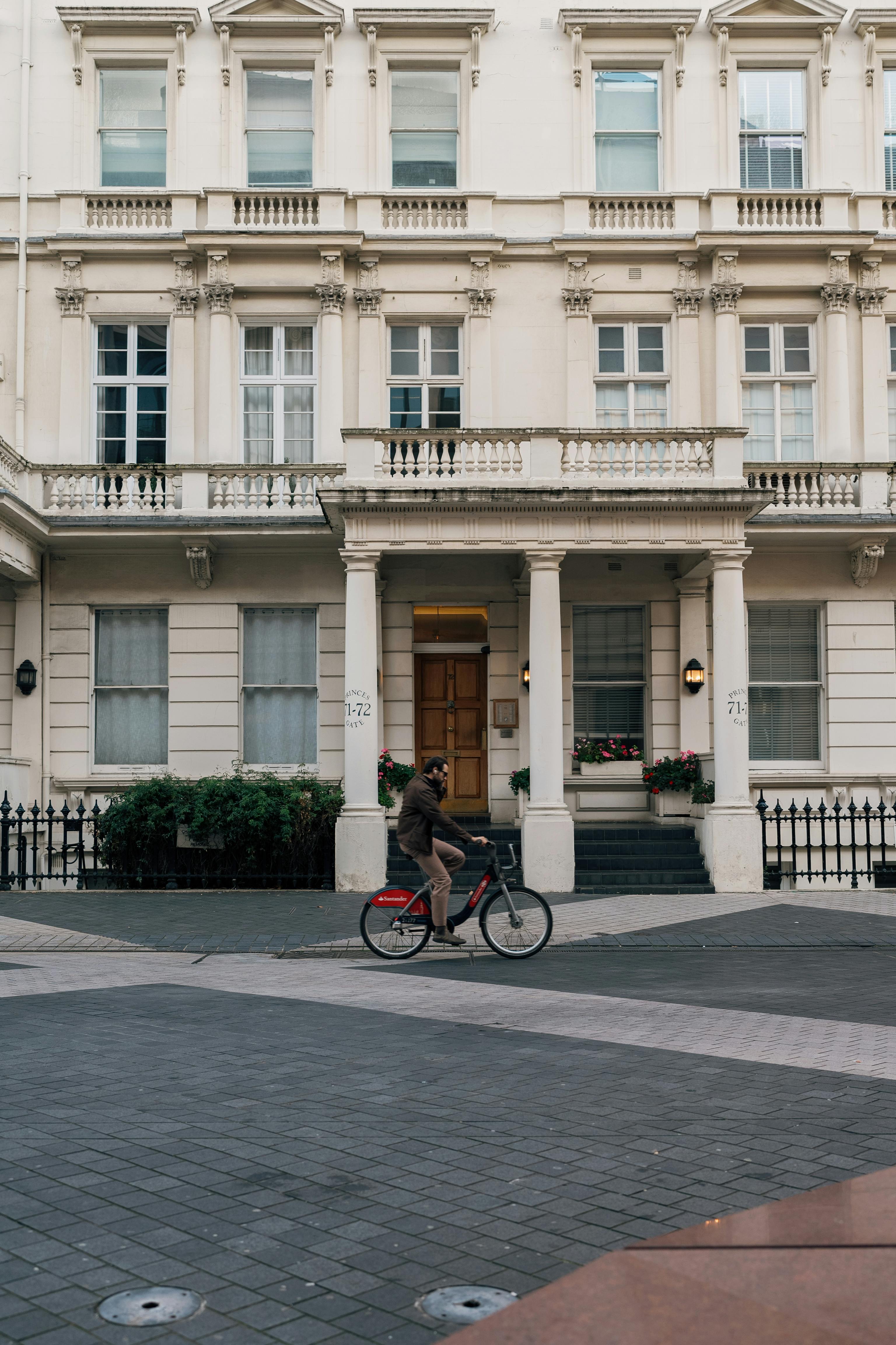 cyclist riding past historic london architecture
