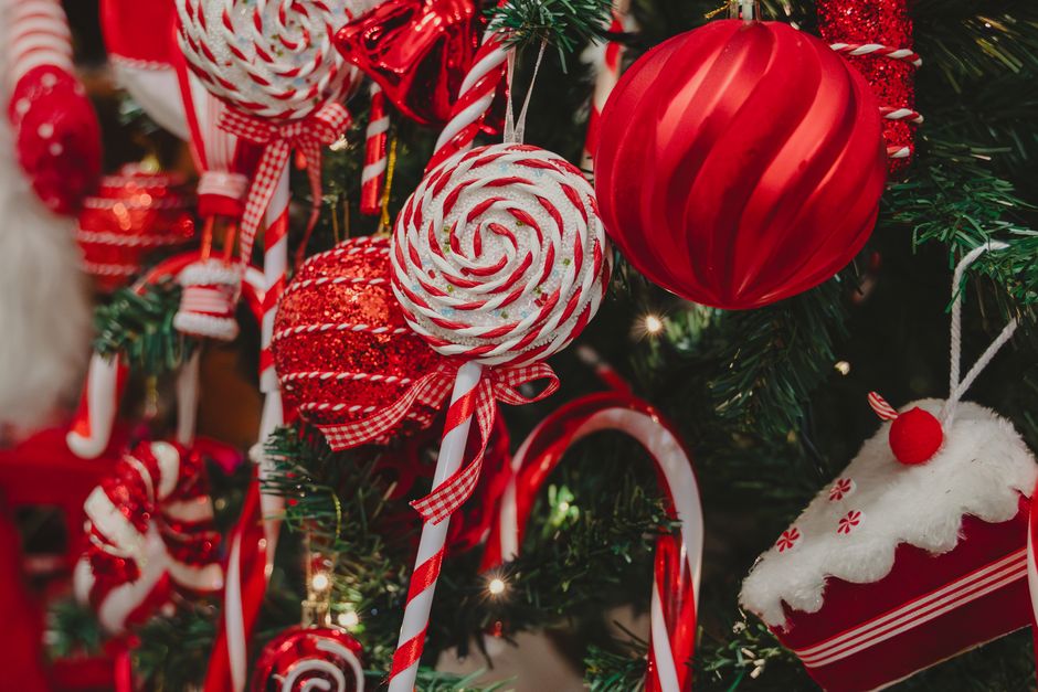 Festive red and white Christmas tree ornaments including candy canes and baubles.