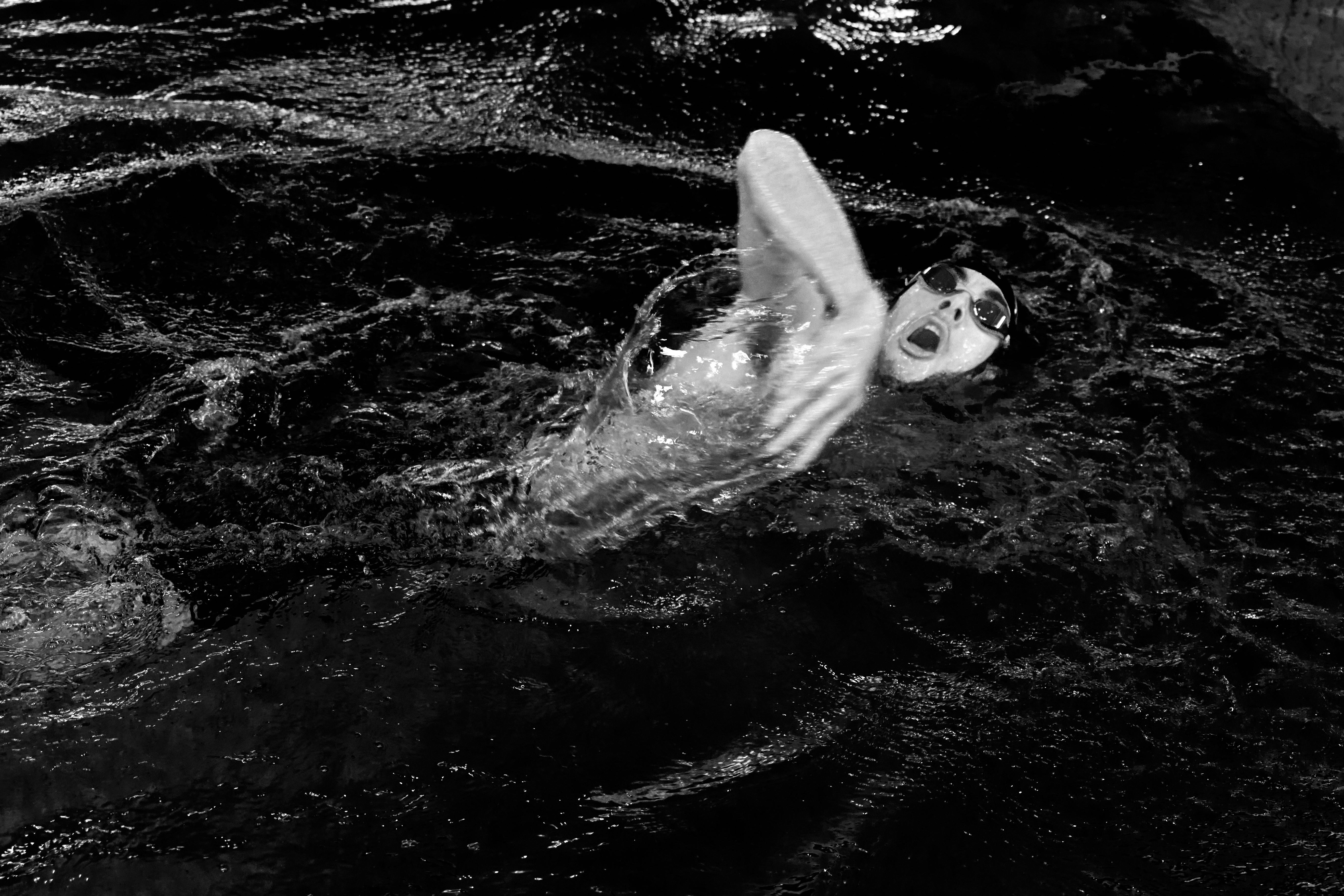 black and white action shot of swimmer in pool