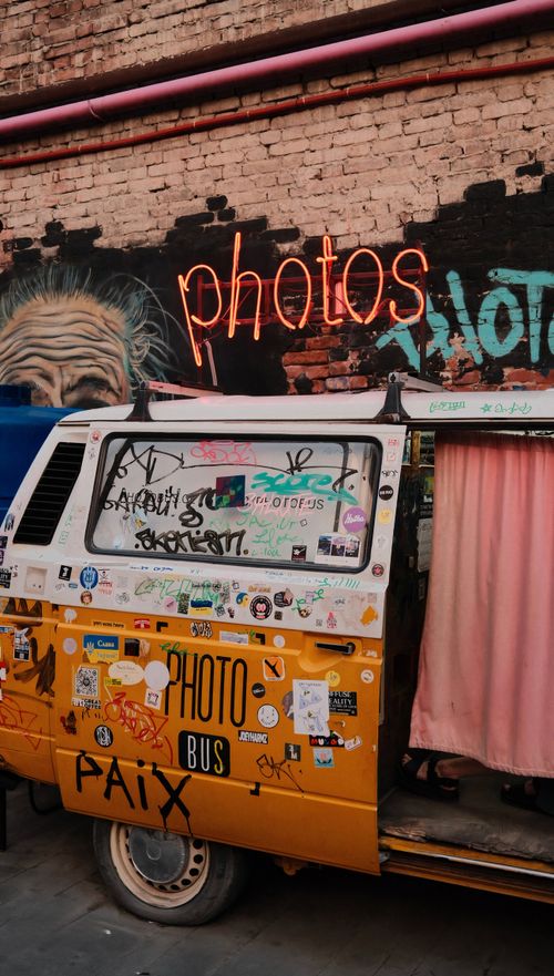 Free Colorful retro photo bus parked in vibrant street art alley in Tbilisi, Georgia. Stock Photo