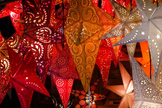 Colorful paper lanterns illuminate a festive night market atmosphere.