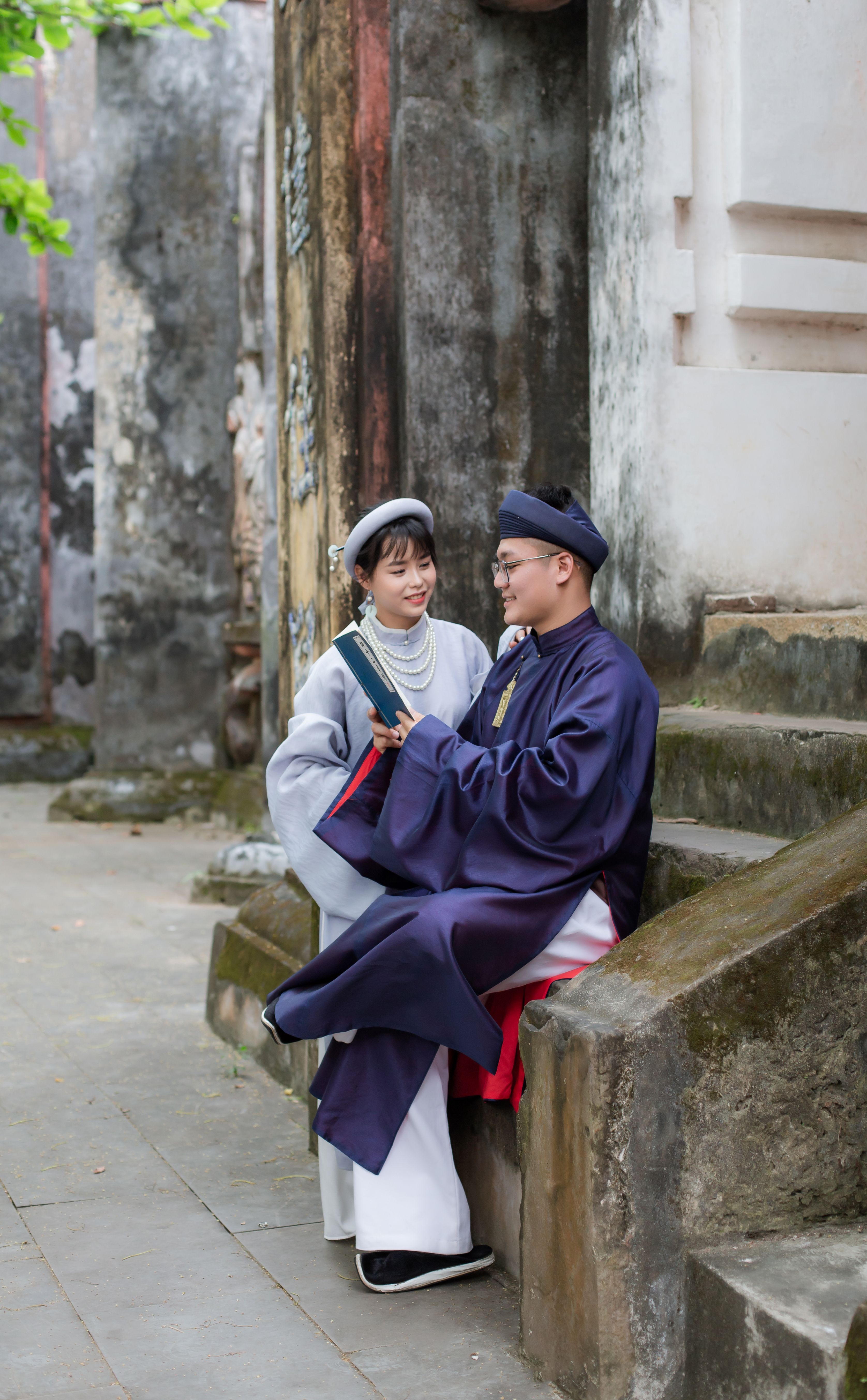 A couple in traditional Vietnamese dress enjoys a moment in the ancient streets of Hội An.