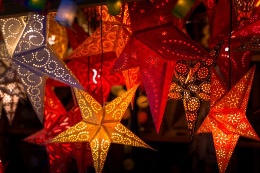 Vibrant star-shaped paper lanterns beautifully lit up, typical of German Christmas markets.