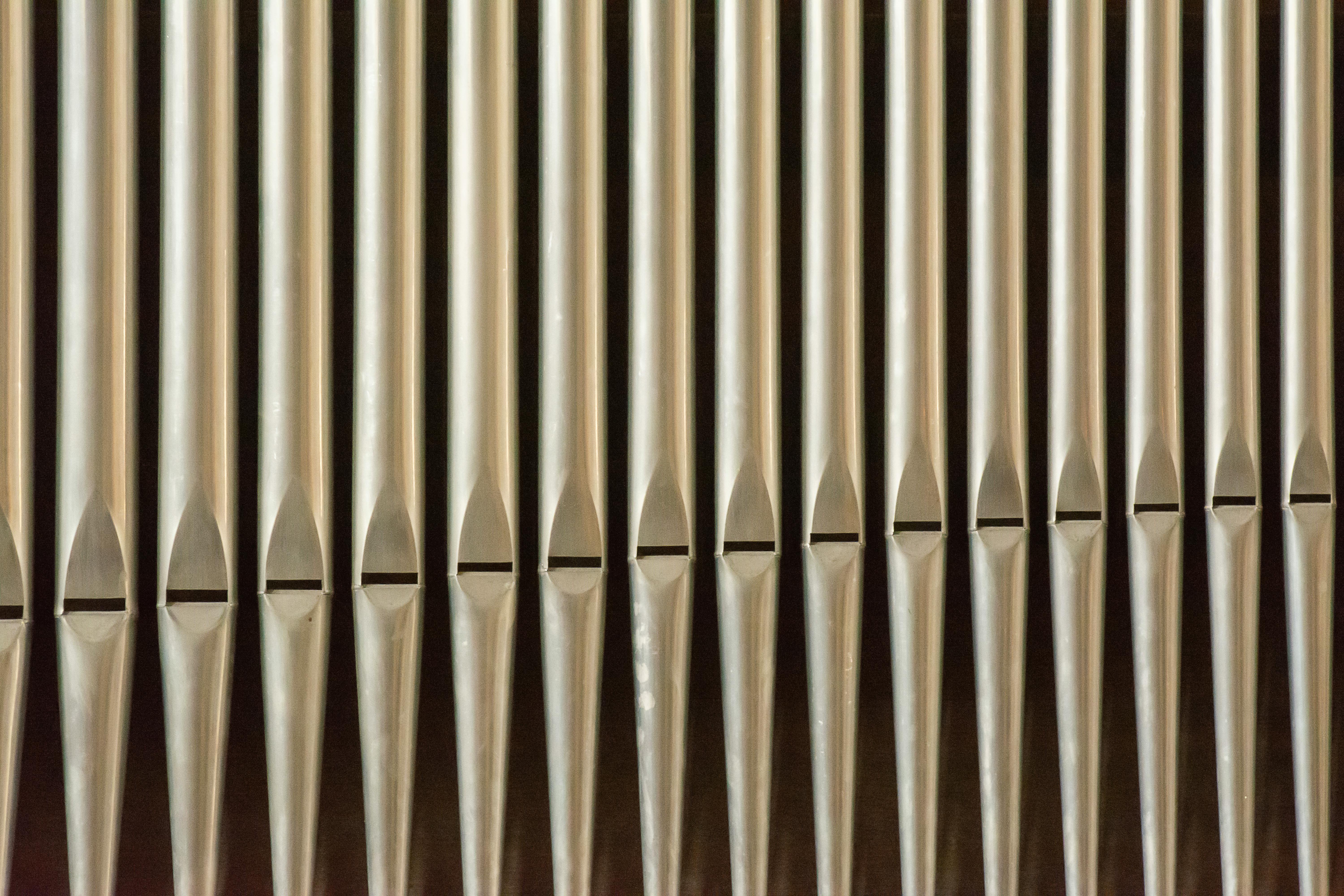 Kostenlos Symmetrische Nahaufnahme von silbernen Orgelpfeifen in einer Reihe, die musikalische Symmetrie zeigt. Stock-Foto