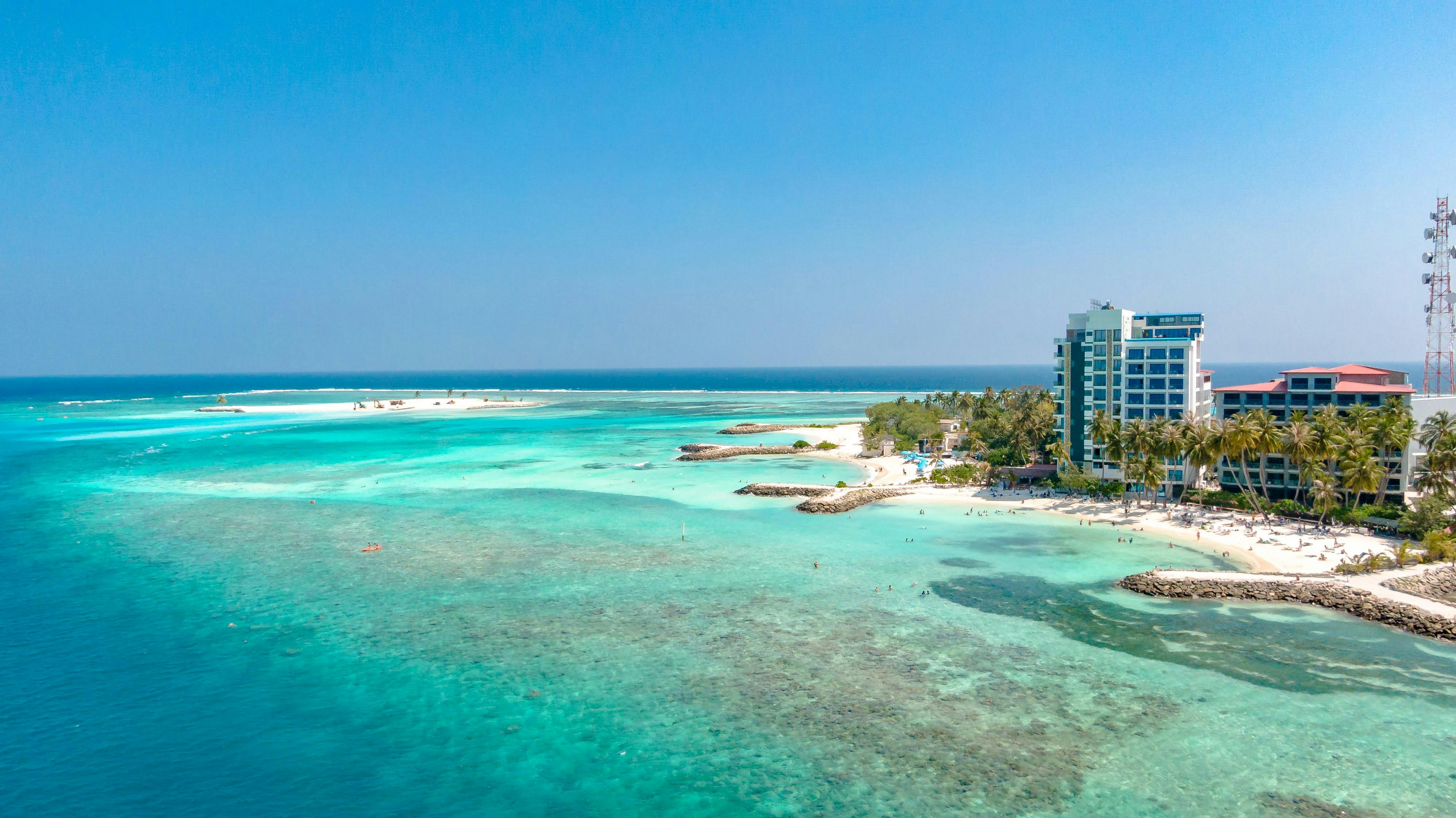 Stunning aerial view of a tropical island in Maldives with turquoise waters and palm trees. - Hulhumalé