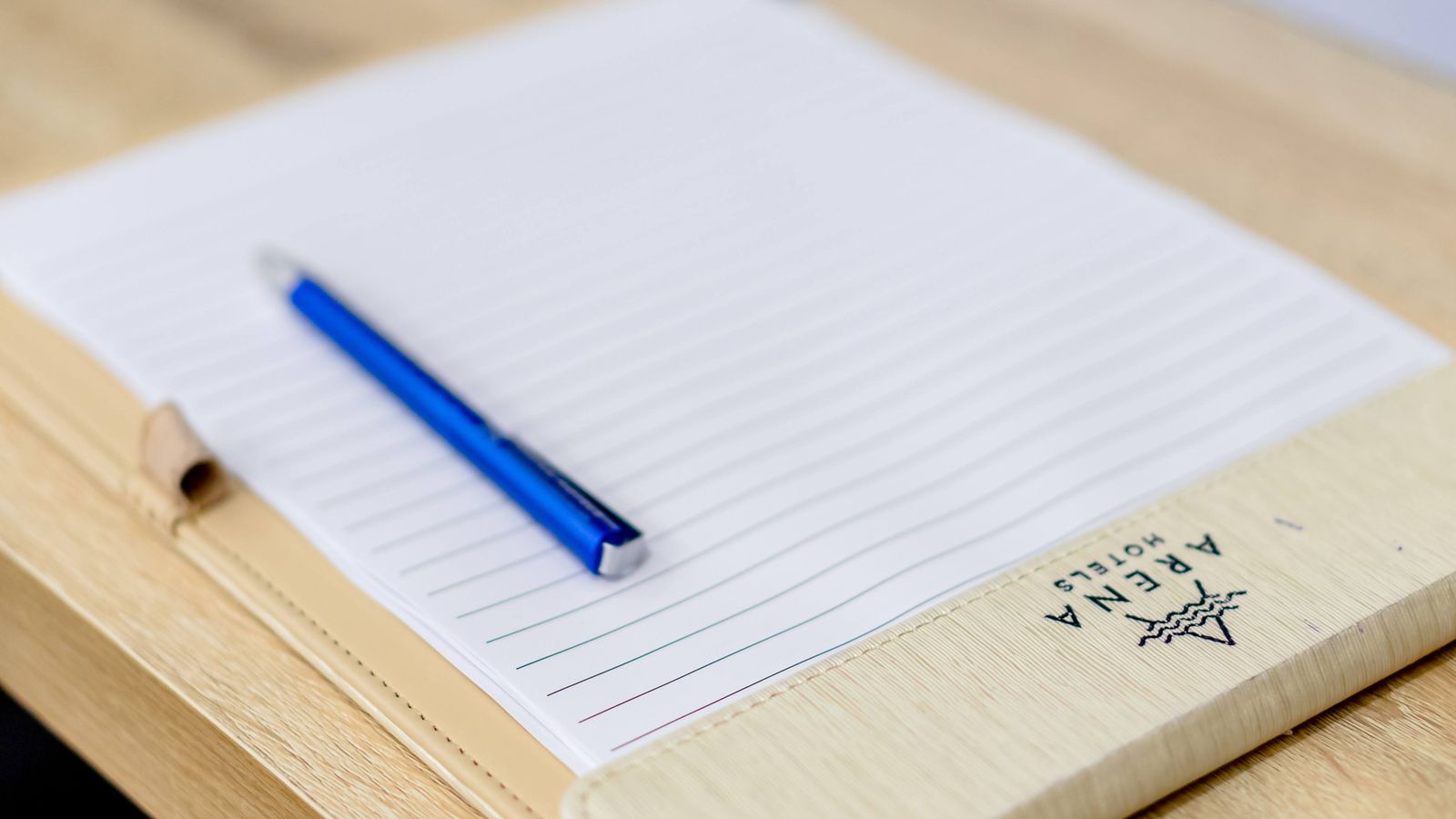 Blue pen resting on an open lined notebook