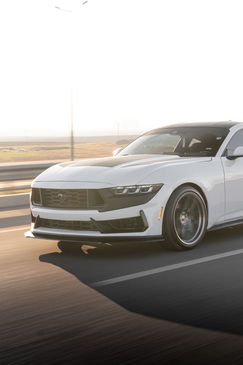 Free White Ford Mustang in motion on an open road during sunset, showcasing sleek design and performance. Stock Photo