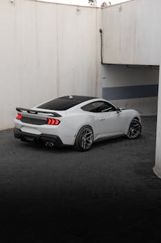 Elegant white Ford Mustang positioned in a modern architectural environment.