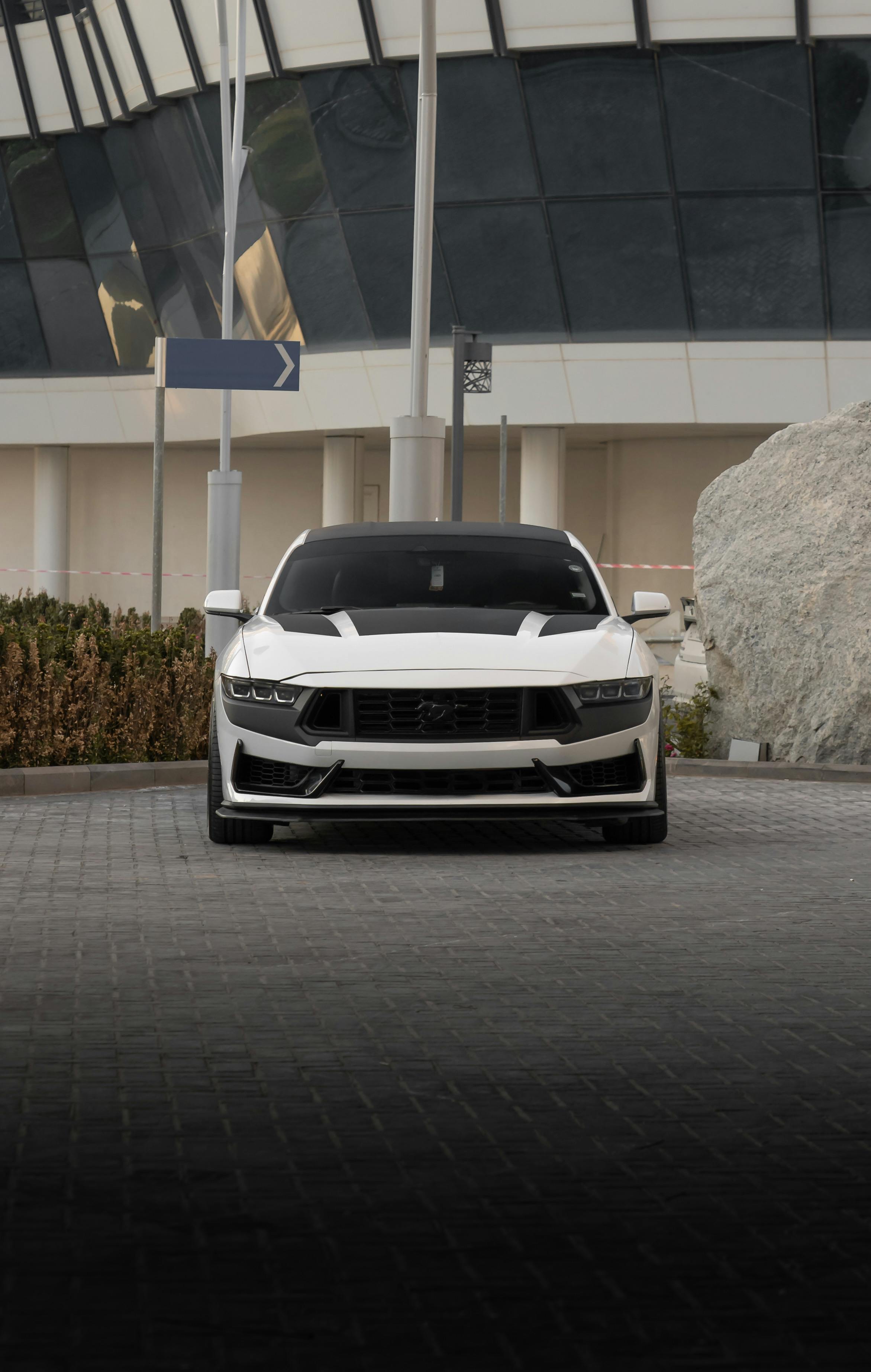 front view of a white ford mustang in urban setting