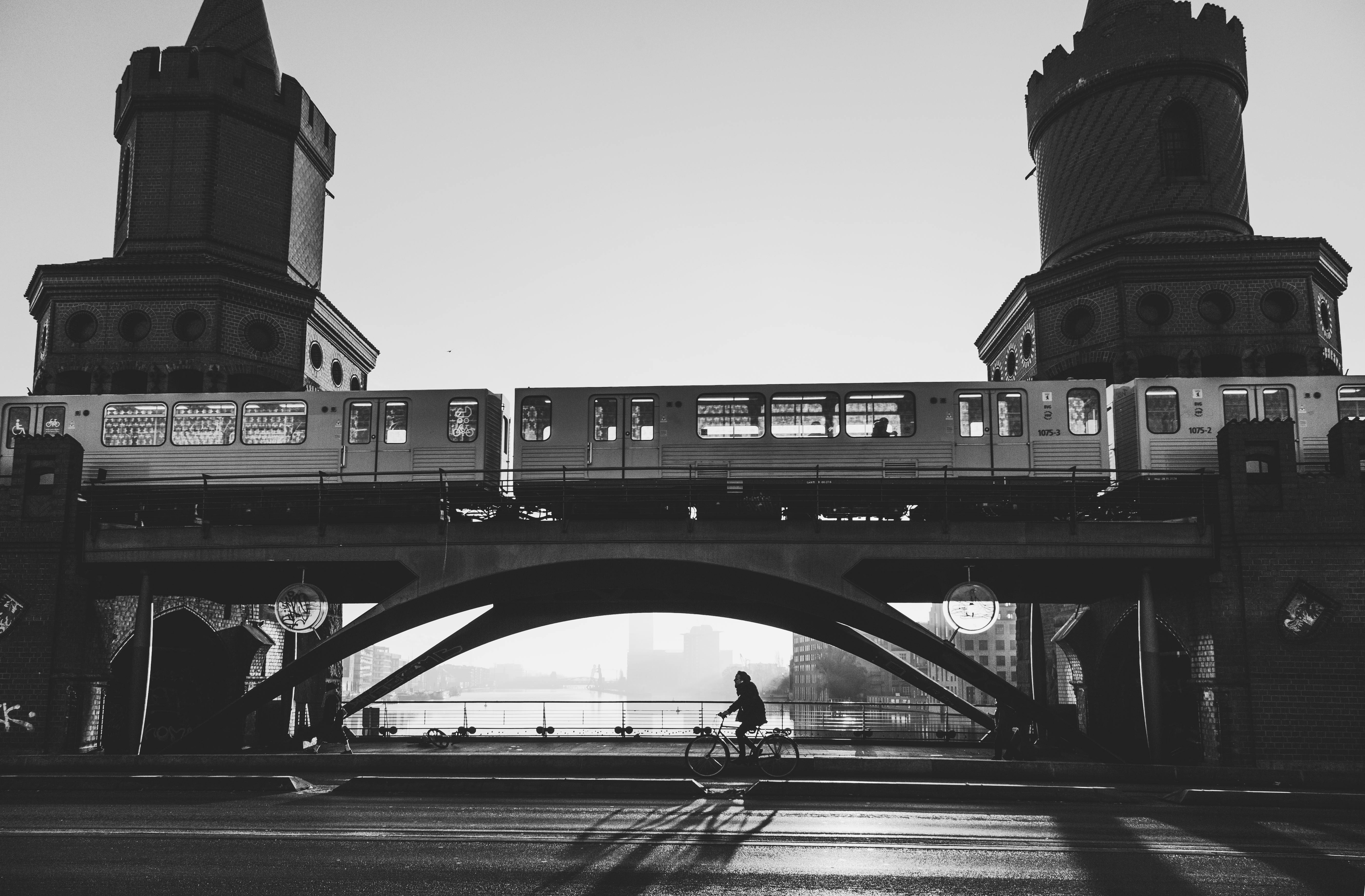 black and white urban scene with bridge and train