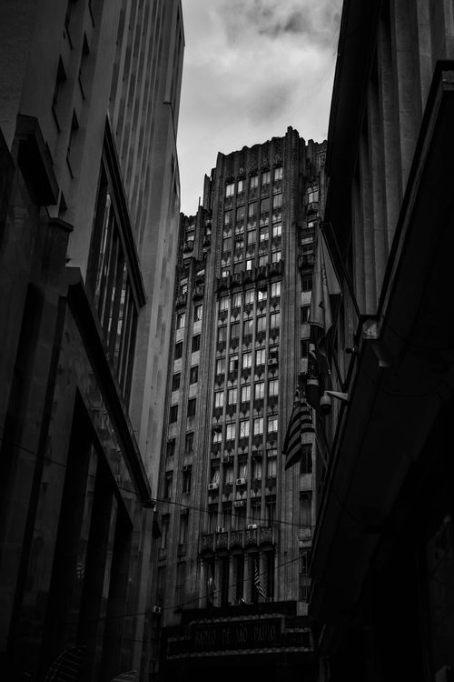 Free Dramatic black and white capture of Gothic Revival skyscrapers in a narrow city alley. Stock Photo