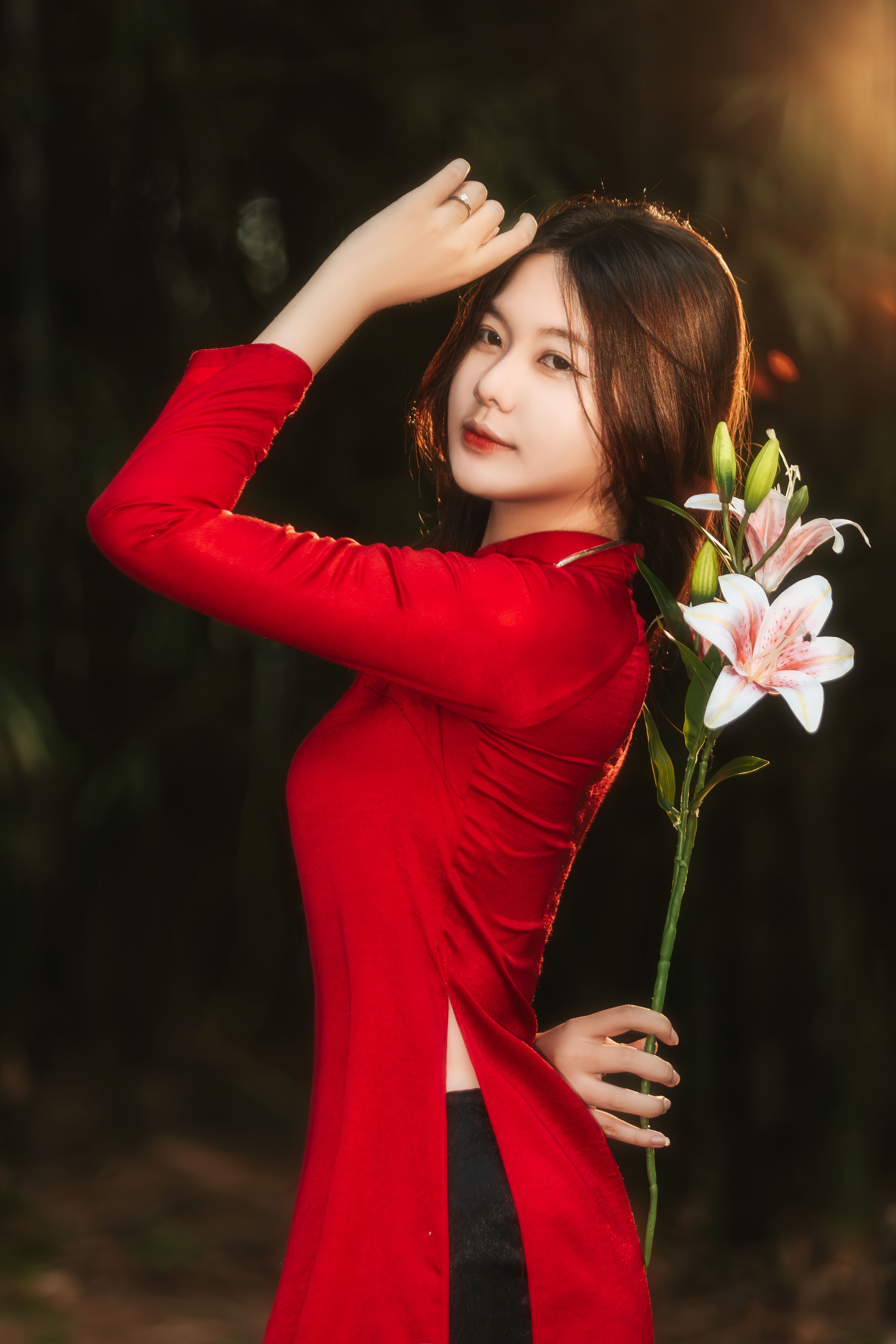 Elegant Woman in Red Dress Holding Lilies Outdoors · Free Stock Photo