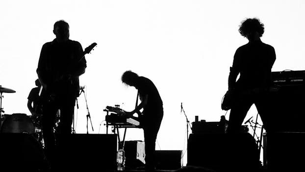 High contrast silhouette of a rock band performing live with musical instruments.