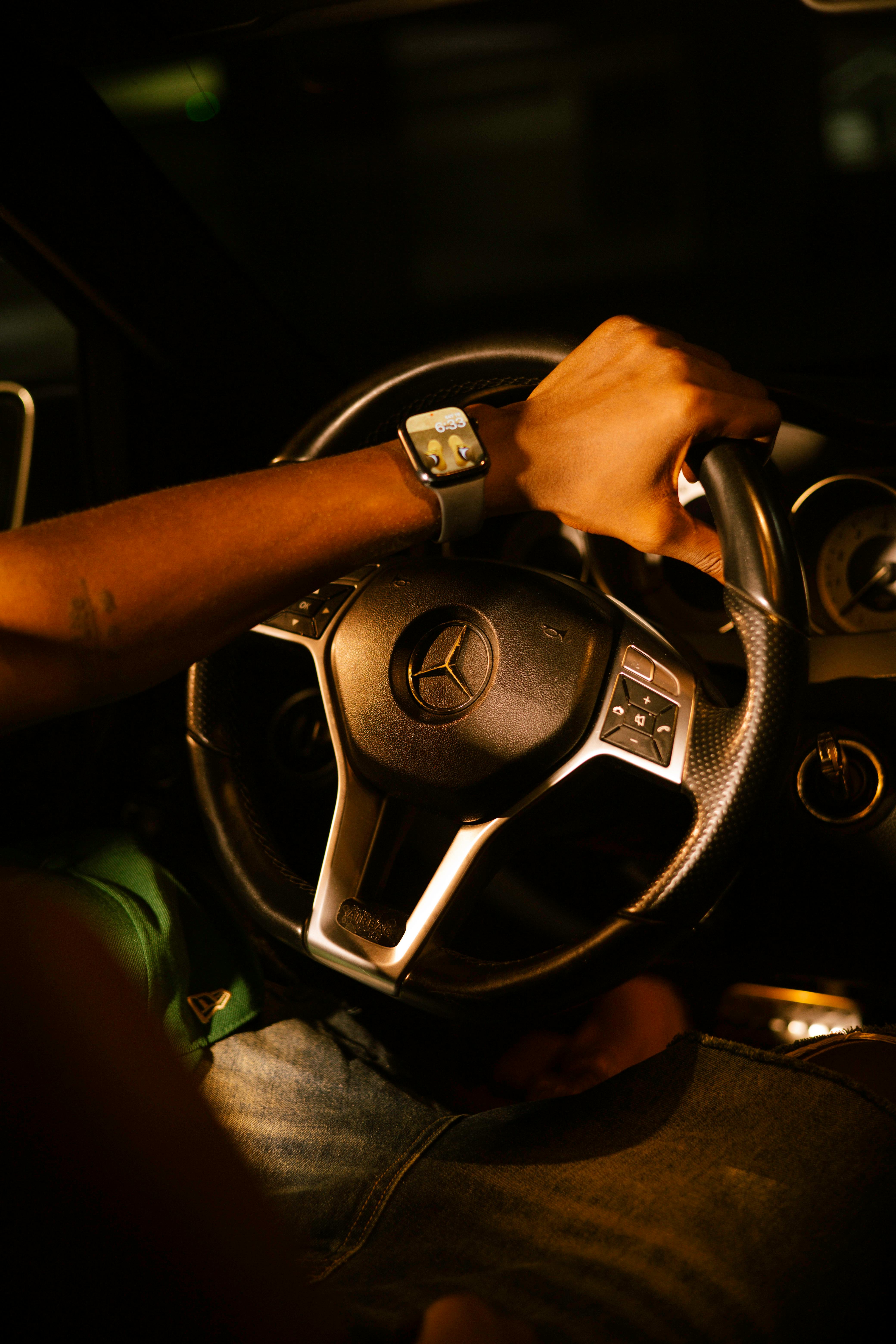 Free Close-up of a hand on luxury car steering wheel at night. Stock Photo
