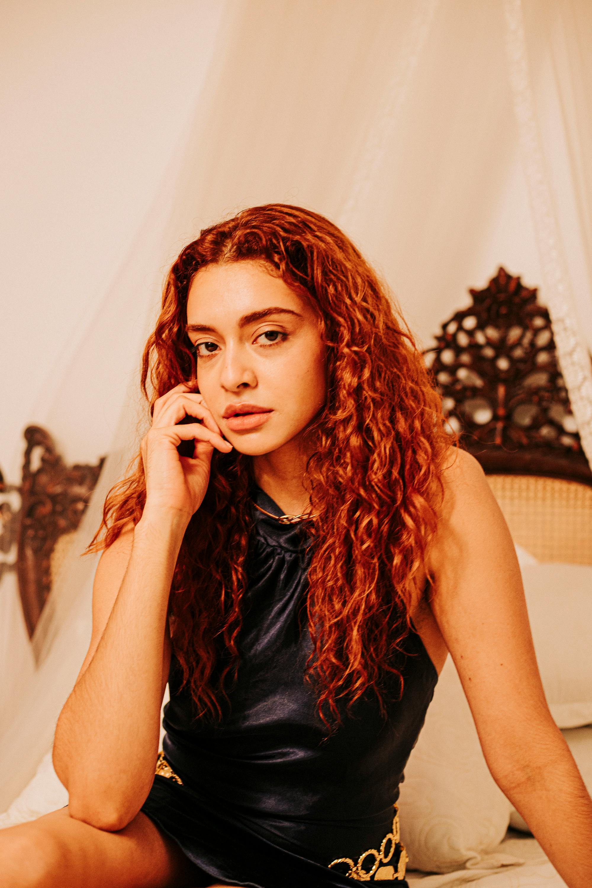 Miễn phí Chân dung một người phụ nữ tóc đỏ trầm ngâm trong bối cảnh đầy phong cách, gợi lên sự thanh lịch và nội tâm. Ảnh lưu trữ