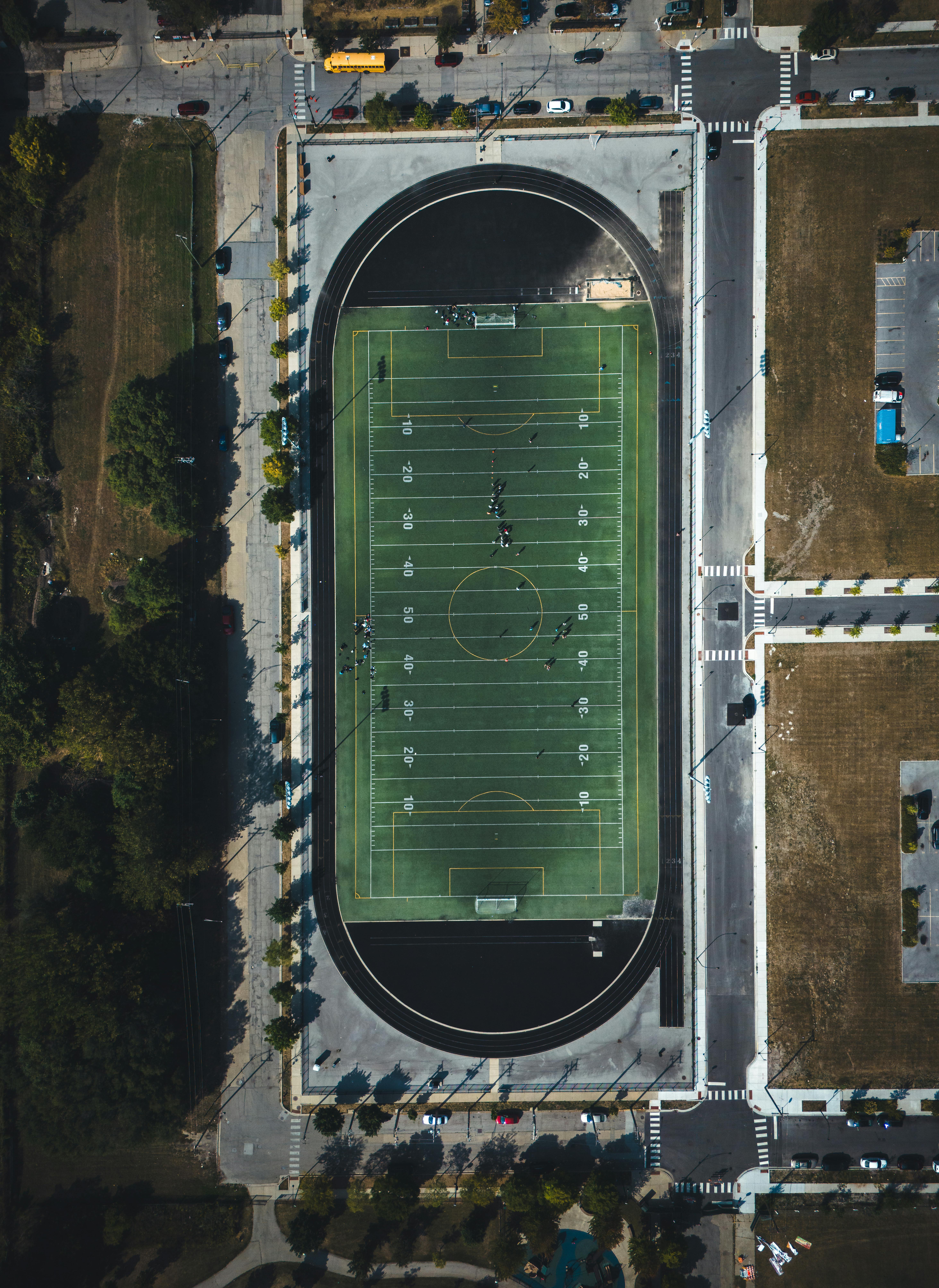 High-angle view of a sports field surrounded by urban streets.