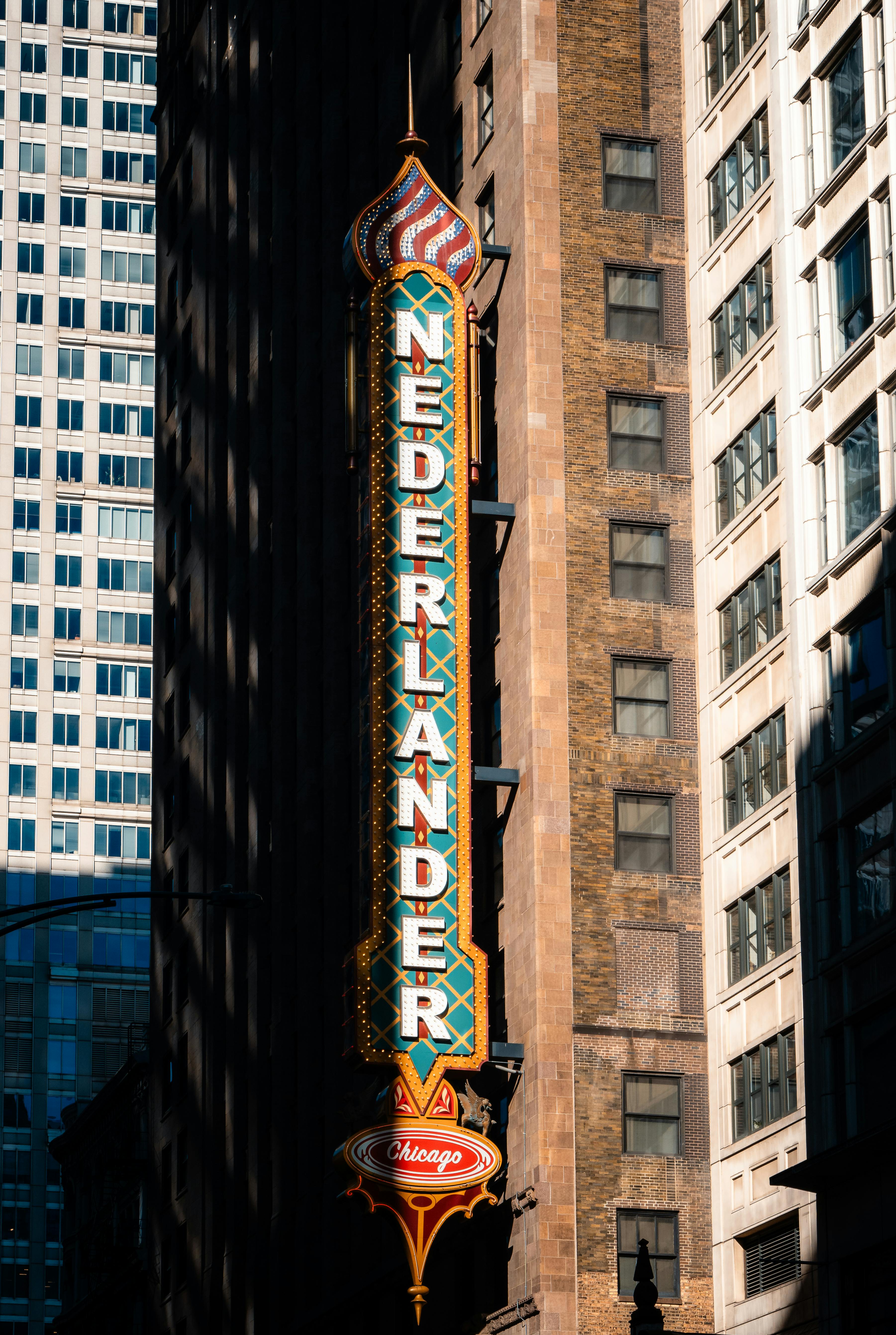 бесплатная Яркая вывеска театра Nederlander в солнечный чикагский день на фоне высоких зданий. Стоковое фото