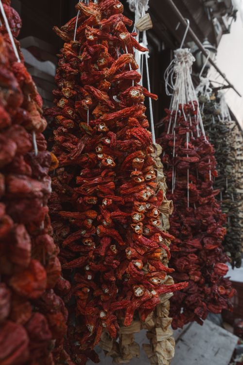Free Vivid strings of dried peppers displayed at a traditional market in Beypazarı, Ankara, Türkiye. Stock Photo