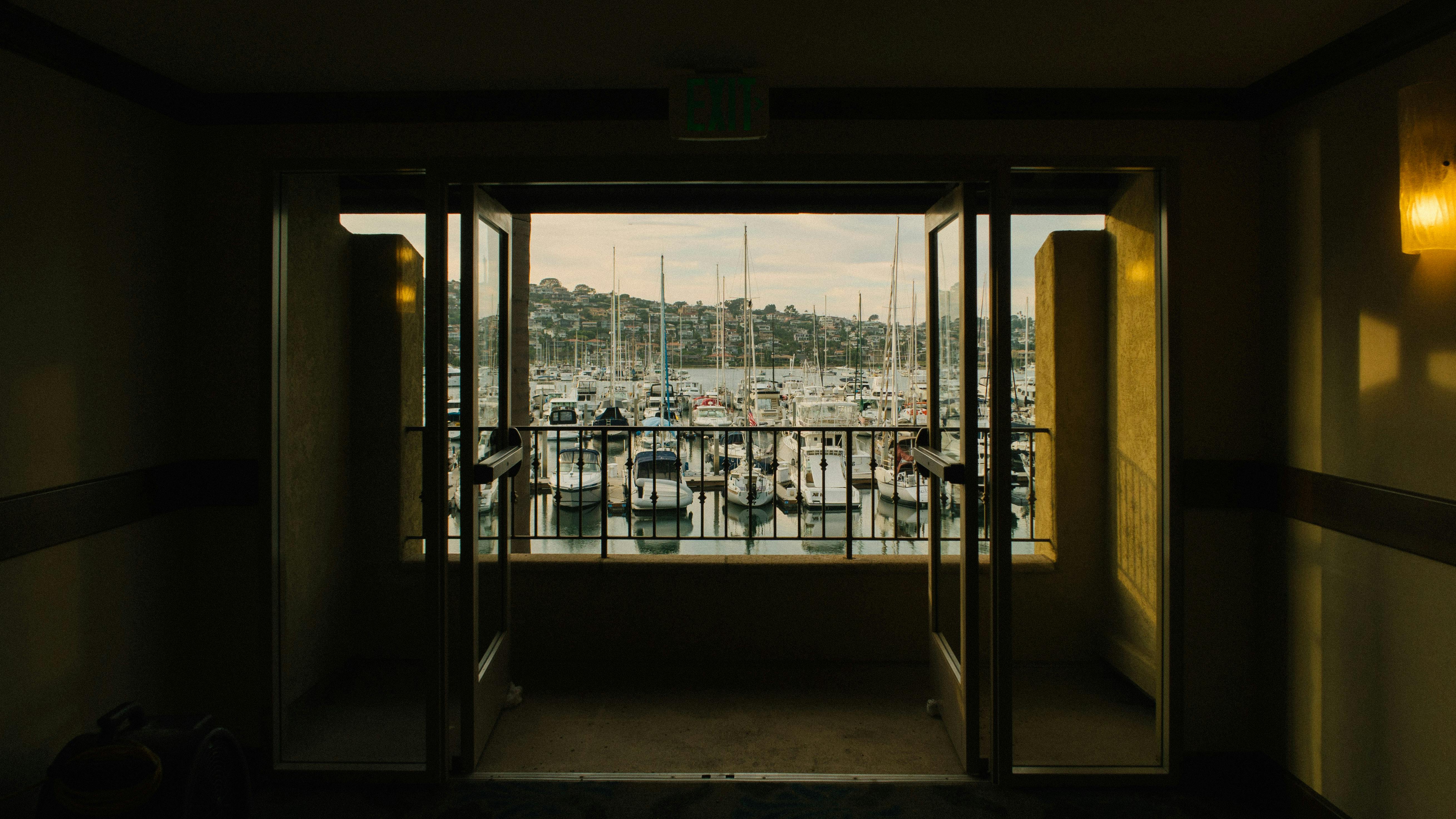 从敞开的阳台窗户望去，码头的宁静景色尽收眼底，水面上停泊着船只