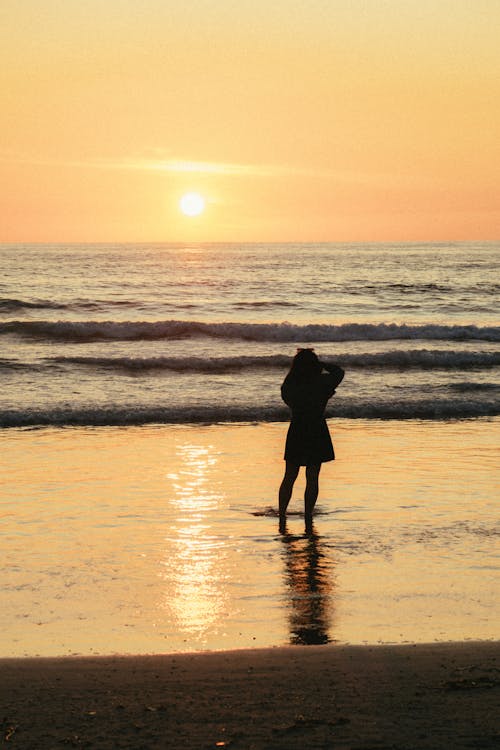 Silhouette Photo Of Woman Standing Beside Seashore