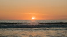 以柔和的海浪和明亮的地平线，捕捉宁静的海洋日落之美