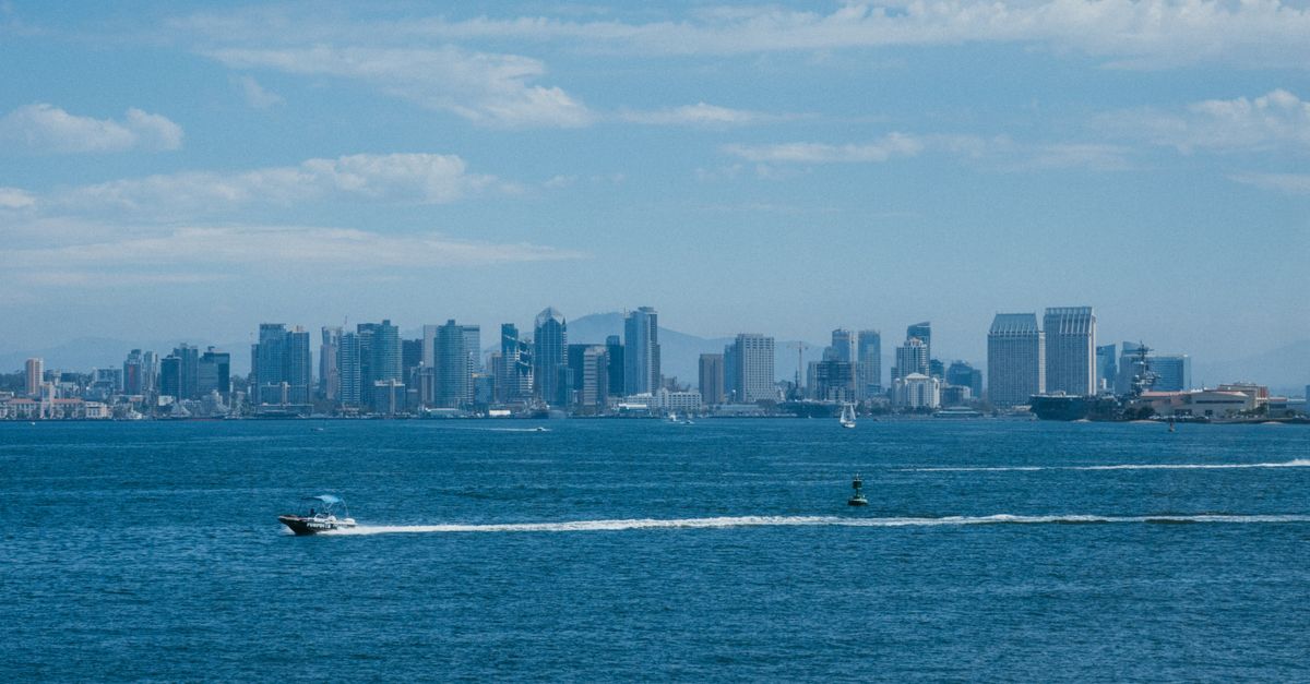 San Diego downtown skyline and waterfront with sailboats under a clear blue sky