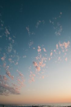 海面上，日落时分一片宁静，云层散落，构成一幅安详的天空景象