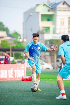Soccer players in action on a sunny day in Hanoi, Vietnam, showcasing local sports culture.