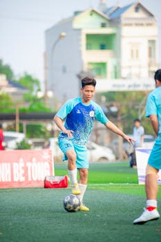 A young soccer player skillfully balancing a ball on the field in Hà Nội, Vietnam.