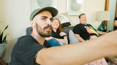 朋友们随意聚在室内舒适的沙发上，欢声笑语