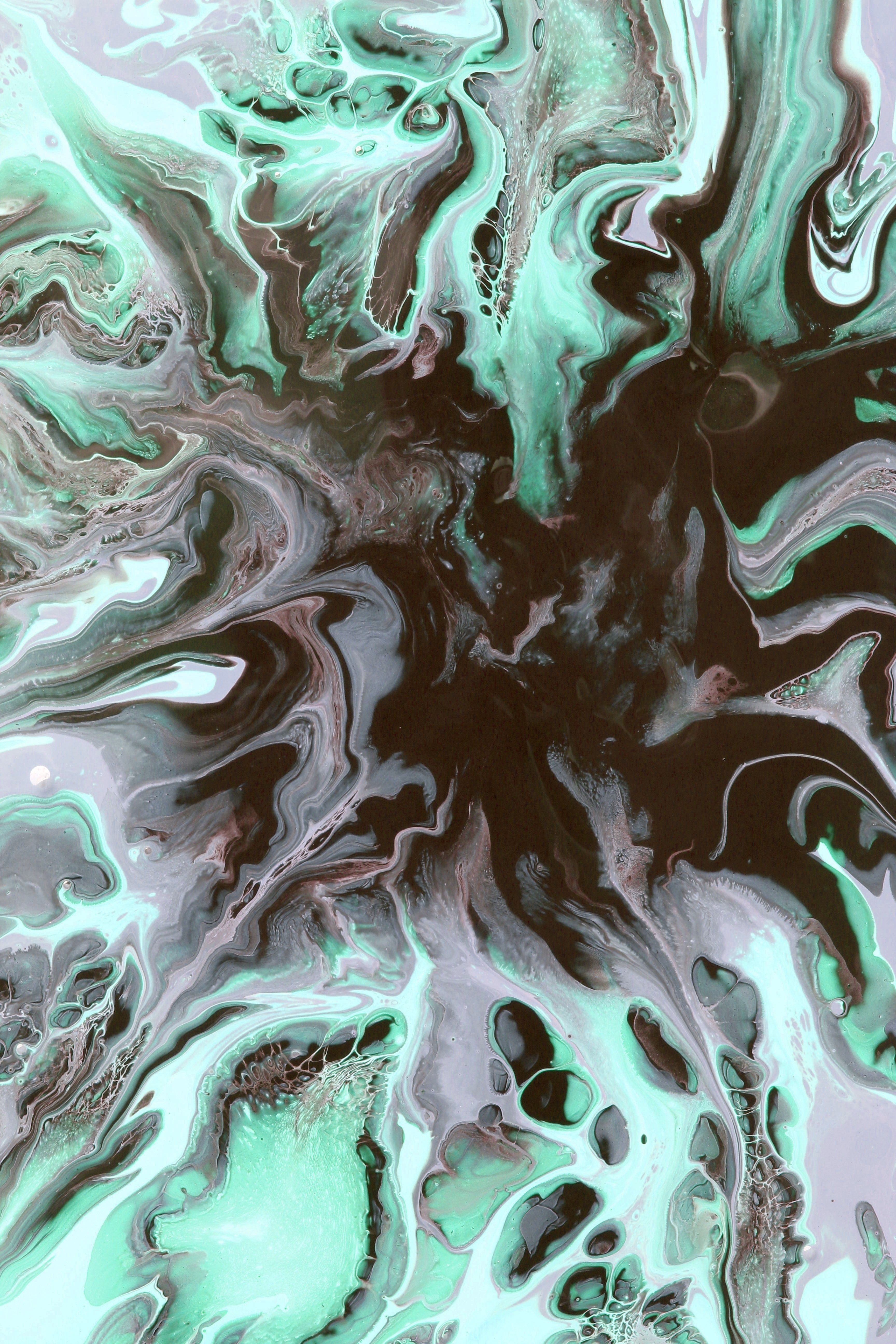A captivating abstract design featuring swirling turquoise and black patterns with fluid art technique.