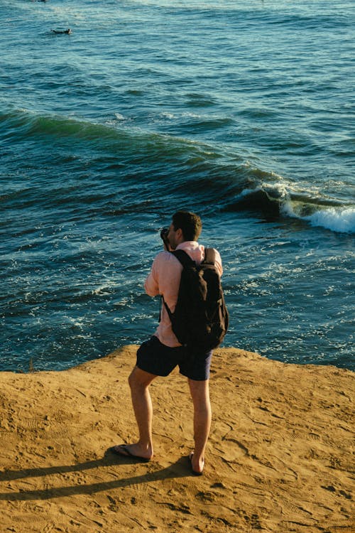 免费 站在蓝色的海洋旁边的人 素材图片
