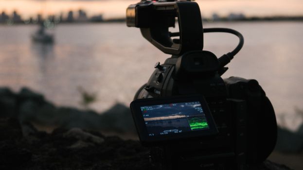 Capture stunning waterfront landscapes with a professional video camera at sunset, perfect for beautiful sunset videos.
